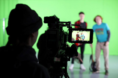 Una troupe gira un video davanti a un green screen